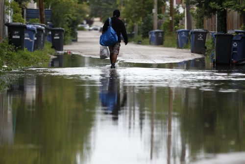August 23, 2015 - 150303  -   A man makes his way through a large puddle in Furby St back lane Sunday, August 23, 2015. John Woods / Winnipeg Free Press