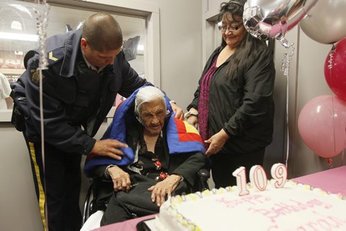 August 24, 2015 - 150824  -  Sarah Harper, who turns 109 today Monday, August 24, 2015, is given a blanket by Corporal Lester Houle, with Aboriginal Policing Services of the RCMP at a celebration of her birthday as her grand-daughter Joan Grieves looks on. John Woods / Winnipeg Free Press