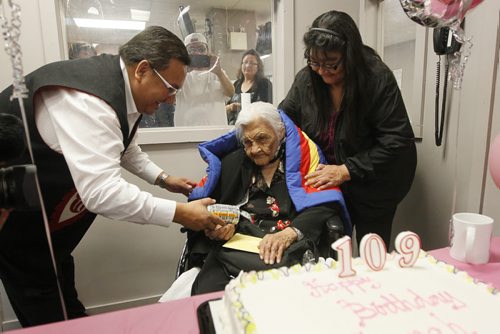 August 24, 2015 - 150824  -  Sarah Harper, who turns 109 today Monday, August 24, 2015, is given a gift by David Harper, Grand Chief for MKO at a celebration of her birthday as her grand-daughter Joan Grieves looks on. John Woods / Winnipeg Free Press