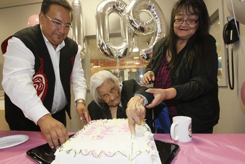 August 24, 2015 - 150824  -  Sarah Harper, who turns 109 today Monday, August 24, 2015, cuts her birthday cake at a celebration of her birthday at Perimeter Airway terminal as David Harper, Grand Chief for MKO and her grand-daughter Joan Grieves looks on. . John Woods / Winnipeg Free Press
