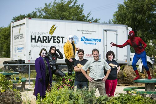 Chris MacDonald (left), David Northcott, and Taryn Brenner, who created a video of superheroes helping Winnipeg Harvest, stand in the community garden with various heroes and villains in Winnipeg on Wednesday, Aug. 26, 2015.   Mikaela MacKenzie / Winnipeg Free Press