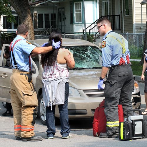 A woman is assisted by Winnipeg Fire Dept first responders after she was hit on her bike at Victor St and St Mathews at aprx 1PM Thursday- She was taken into an ambulance for medical care-Breaking News- Aug 27, 2015   (JOE BRYKSA / WINNIPEG FREE PRESS)