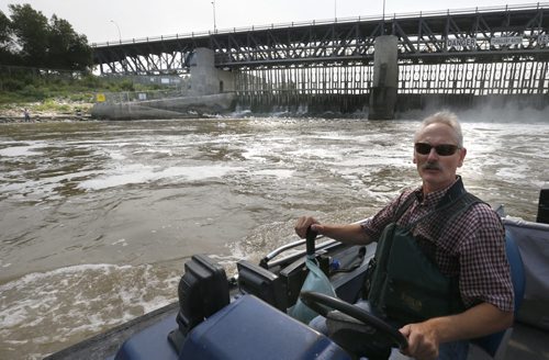 Ken Schultz in his boat on the Red River with the fish ladder and the St. Andrews Lock and Dam in back. He is concerned about American White Pelicans getting tangled in fishing line near the fish ladder by the St. Andrews Lock and Dam in Lockport Mb. Ashley Prest story Wayne Glowacki / Winnipeg Free Press August 28  2015