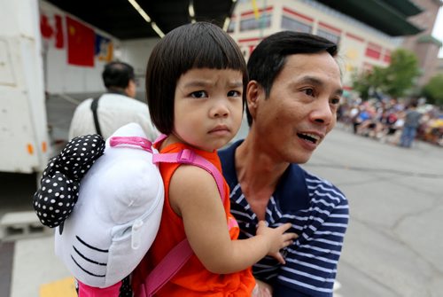 Trong Luong holding his daughter, Cindy, who is almost 2 years old, at the Chinatown Street Festival, Saturday, August 29, 2015. (TREVOR HAGAN/WINNIPEG FREE PRESS)