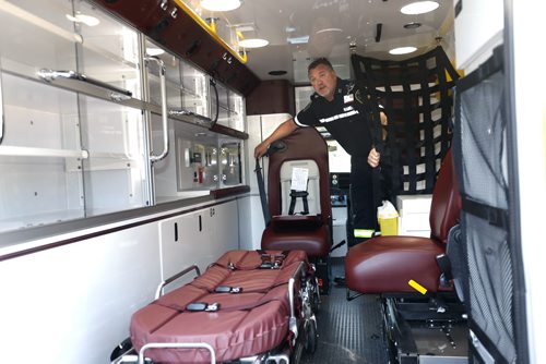 Brent Curry, a front line Paramedic in Portage la Prairie gives a tour to the media of a  new replacement ambulance parked in front of the Manitoba Legislative Bld. Tuesday for the news conference. Brent shows one of the chairs has a  built in child restraint seat if needed and at right the new chair for Paramedics to safely care for a patient while travelling.  The province announced it has purchased 52 new ambulances with new suspension system and other features.   Larry Kusch story Wayne Glowacki / Winnipeg Free Press Sept.1  2015