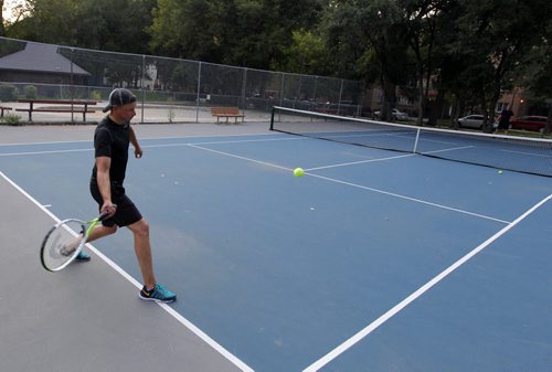 (left) Terry Reilly and (right serving to him) Chris Morrissette play some tennis on the nice newly fixed up courts at McFadden Park downtown. BORIS MINKEVICH / WINNIPEG FREE PRESS PHOTO Sept. 1, 2015