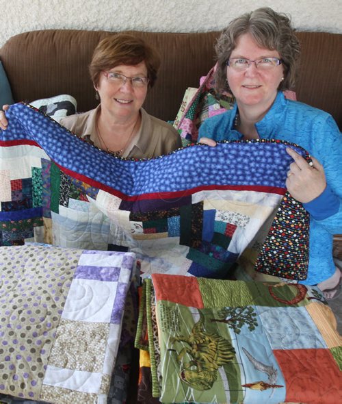 Barbara Wynes, Chair of Refuge Winnipeg with Dr. Sandra Shaw, right, holds quilts  that were made by more than a dozen women for three Syrian refugee families sponsored by Refuge Winnipeg who are not here yet.- See Carol Sanders story- Sept 03, 2015   (JOE BRYKSA / WINNIPEG FREE PRESS)
