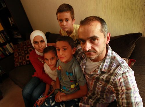 Jude Kasas, president of the Syrian Assembly of Manitoba poses at home with his wife Alia Harb, and left to right, his daughter   Dujahn 10 yrs , Son Kemiee 7yrs, and Jadd 8yrs (top). Jude came to Canada 15 years ago and says the drowned boy couldve been one of his kids if he hadnt come to Canada when he did.  He said its a wake up to Canada to accept more refugees to this country. For sanders story. September 3, 2015 - (Phil Hossack / Winnipeg Free Press)