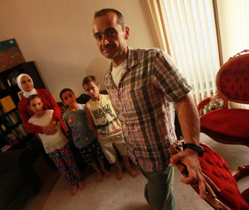 Jude Kasas, president of the Syrian Assembly of Manitoba poses at home with his wife Alia Harb, and left to right, his daughter   Dujahn 10 yrs , Son Kemiee 7yrs, and Jadd 8yrs. Jude came to Canada 15 years ago and says the drowned boy couldve been one of his kids if he hadnt come to Canada when he did.  He said its a wake up to Canada to accept more refugees to this country. For sanders story. September 3, 2015 - (Phil Hossack / Winnipeg Free Press)