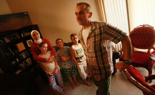 Jude Kasas, president of the Syrian Assembly of Manitoba poses at home with his wife Alia Harb, and left to right, his daughter   Dujahn 10 yrs , Son Kemiee 7yrs, and Jadd 8yrs. Jude came to Canada 15 years ago and says the drowned boy couldve been one of his kids if he hadnt come to Canada when he did.  He said its a wake up to Canada to accept more refugees to this country. For sanders story. September 3, 2015 - (Phil Hossack / Winnipeg Free Press)