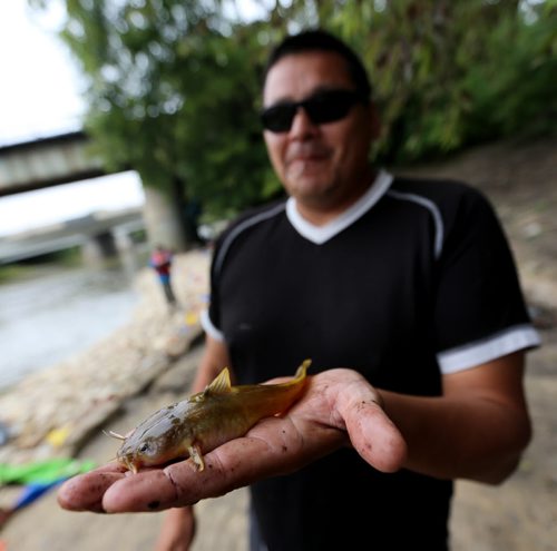 Keith Flett, from Peguis, shows of an 18cm catfish he reeled in during a charity fishing derby at The Forks in support of youth programs at Marymound, Saturday, September 5, 2015. (TREVOR HAGAN/WINNIPEG FREE PRESS)