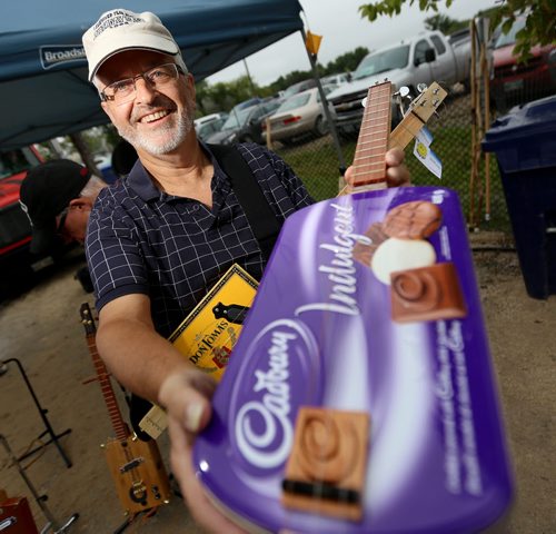 Chris Freeman of Smilin' Emoji, shows off his handmade cigar box guitars at the St.Norbert Farmers Market, Saturday, September 5, 2015. (TREVOR HAGAN/WINNIPEG FREE PRESS)