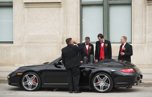 DAVID LIPNOWSKI / WINNIPEG FREE PRESS 150905 September 5, 2015  A group of men in a wedding party check out a Porsche outside of Union Station on Main Street Saturday September 5, 2015
