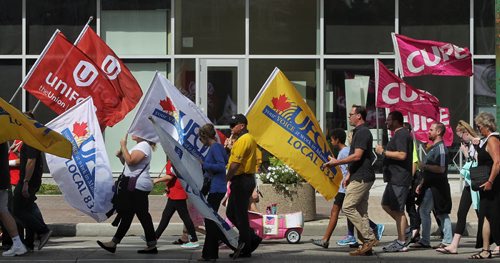 Participants in the Labour Day March make their way along Portage Avenue Monday afternoon.   150907 September 07, 2015 MIKE DEAL / WINNIPEG FREE PRESS