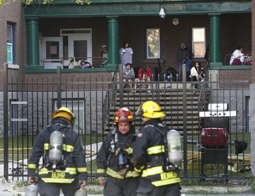 Residents of an apartment building at 519 Burnell St. near Ellice Ave. watch Winnipeg Fire Fighters extinguish a fire in the basement of their building Wednesday morning. Wayne Glowacki / Winnipeg Free Press September 9 2015