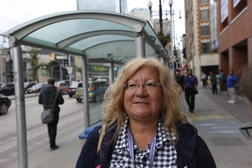 Carolyn Alexander keeps an eye out for her bus at the bus stop on Portage Ave. at Donald Thursday. Winnipeggers will have to get used to a reduced level of Transit service as the department struggles with a manpower shortage and problematic buses.Ashley Prest story Wayne Glowacki / Winnipeg Free Press September 10 2015