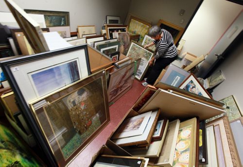 Judy Cumberford sorts through  donated art amassed for the "Art from the Attic Sale" on Sept 20  its organized by GrandsnMore to raise money for Stephen Lewis Fdn helping AIDS orphans in Africa who are being raised by their grannies. Its one Cdn charity thats helping people help themselves so they can maintain a civil society and dont end up in chaos and driven from their homes as refugees or economic migrants. September 11, 2015 - (Phil Hossack / Winnipeg Free Press) SEE RELEASE?