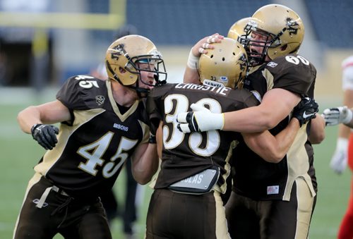 Manitoba Bisons' Alex Christie is congratulated after he scores a touchdown against the Calgary Dinos' during their football game, Friday, September 11, 2015. (TREVOR HAGAN/WINNIPEG FREE PRESS)