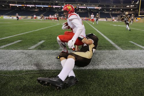 Manitoba Bisons' Cam Teschuk tackles Calgary Dinos' Michael Klukas during their football game, Friday, September 11, 2015. (TREVOR HAGAN/WINNIPEG FREE PRESS)