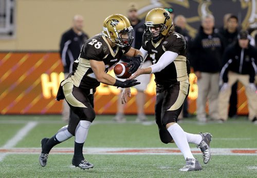 Manitoba Bisons' quarterback, Theo Deezar, right, hands the ball to Jamel Lyles while playing against the Calgary Dinos' during their football game, Friday, September 11, 2015. (TREVOR HAGAN/WINNIPEG FREE PRESS)