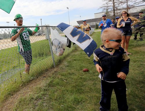 Justin Dickie, from Pense, Saskatchewan, tries to get a high five from Caleb Nickel, 5, who was unwilling, prior to the Banjo Bowl, Saturday, September 12, 2015. (TREVOR HAGAN/WINNIPEG FREE PRESS)