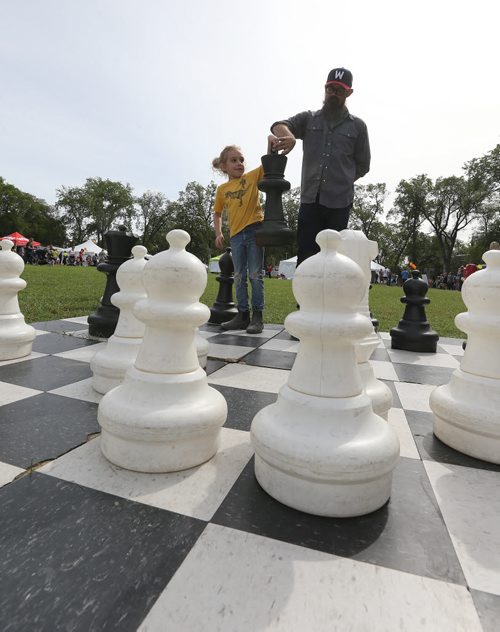 Chris Sawatzky and his son Rollin, 6, play chess on an oversized board at Manyfest on Broadway on Sept. 12, 2015. Rollin was giving up his king after losing the game to his dad. Photo by Jason Halstead/Winnipeg Free Press
