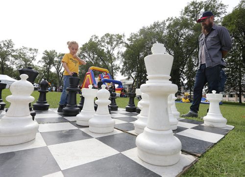 Chris Sawatzky and his son Rollin, 6, play chess on an oversized board at Manyfest on Broadway on Sept. 12, 2015. Rollin was pondering his next move. Photo by Jason Halstead/Winnipeg Free Press
