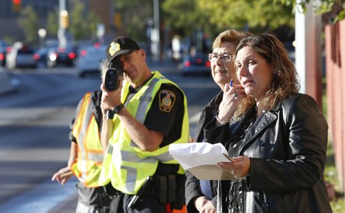 From right, as Tasia Karagiannis and Donna Fissel record instances of risky behaviour at the crosswalk on Balmoral St. near Sister MacNamara School Wednesday morning Winnipeg Police Const. Richard Aminot keeps his eye on speeders. The data is being collected  for the  CAA Manitoba annual Back to School Safety Assessment .  Jessica Botelho-Urbanski story Wayne Glowacki / Winnipeg Free Press September 16 2015