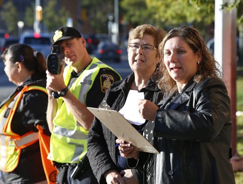 From right, as Tasia Karagiannis and Donna Fissel record instances of risky behaviour at the crosswalk on Balmoral St. near Sister MacNamara School Wednesday morning  Winnipeg Police Const. Richard Aminot keeps his eye on speeders. The data is being collected  for the  CAA Manitoba annual Back to School Safety Assessment .  Jessica Botelho-Urbanski story Wayne Glowacki / Winnipeg Free Press September 16 2015