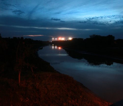 With lights from US and Canadian Border stations reflected the red river flows arcorss the international boundary near Emerson. September 16, 2015 - (Phil Hossack / Winnipeg Free Press)  See Carol Sanders story, BUSY SUMMER ON MANITOBAS UNDERGROUND RAILROAD  -- While thousands seeking asylum in Europe amass on its borders, a growing surge of refugee claimants quietly slip into Canada under the cover of darkness at a Manitoba border town. Most local residents dont see them because they arrive under the cover of darkness while people are sleeping, said Wayne Arseny, Emersons former mayor. They dont want be to be spotted. CBSA says nearly twice as many asylum seekers   walked up to the port of entry into Canada by way of Manitoba this summer compared to last  year. Some in the settlement community are calling the influx the underground railroad with many refugee claimants crossing here and moving on to Toronto and B.C.  Why here? Why now? What does it mean for Winnipeg and its already overwhelmed settlement services? 15 SANDERS (ART?)