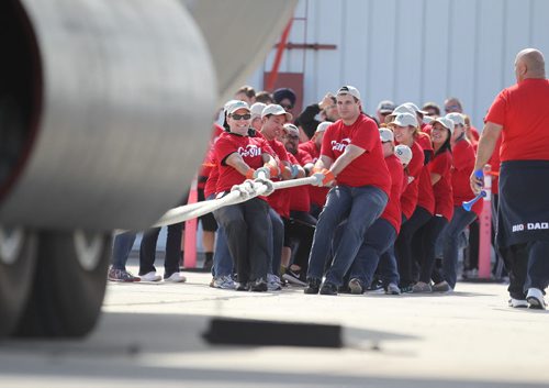 Employees with Cargill give it their all as they try to be the fasted in pulling a Hercules aircraft over a finish line in the 12th annual Plane Pull with proceeds from the  event  going to the United Way.   Standup photo  Sept 18, 2015  Ruth Bonneville / Winnipeg Free Press
