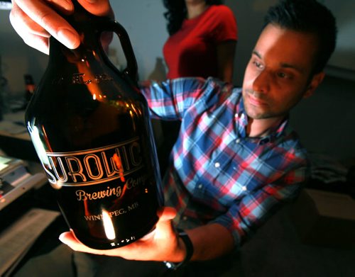 INTERSECTION - Daivin examines a growler he designed and sandblasted with his wife Leah Macdonald, owner sof North City Growlers, make personalized beer growlers, which have has shipped all over the world, as far as Norway and Hawaii. They come in two sizes, and in glass, ceramic or stainless steel. (Manitoba liquor marts only use glass ones, which is why he started an on-line biz - now most of his sales are outside the province...) Dave Sanderson Story. September 18, 2015 - (Phil Hossack / Winnipeg Free Press)