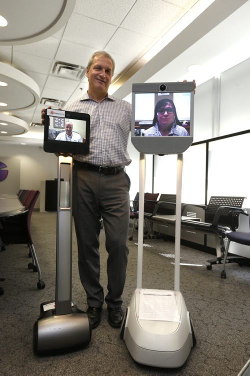 Rick Duha, Managing Director of the Duha Group with staff Meggie Kornelsen, Executive Assistant operating their "C3P0" and at left, Douglas Crabb, Director of Operations controls their "R2-D2". Robots in the workplace. Geoff Kirbyson Story. Wayne Glowacki / Winnipeg Free Press September 21 2015