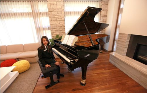 Ten yr old Sarah with her new Fazoli piano. Most people have never heard of piano brand Fazioli before, but for a pianist  its like hearing the name Ferrari, or Lamborghini. They are regarded today as being the finest pianos ever made  and this is the first one ever to come to Winnipeg. Chick Corea and Herbie Hancock have both signed the harp inside the instrument. (so I gues it's "used". Holly Harris story.  SEPTEMBER 21, 2015 - (PHIL HOSSACK / WINNIPEG FREE PRESS)