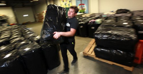 Cody Cleave stacks wrapped bales of supplies at the Canadian Lutheran World Relief warehouse Monday, supplies to be shipped to  Syrian refugees in Jordan.  For Sanders story about response to feds weekend news that Canada is welcoming more Syrian refugees. SEPTEMBER 21, 2015 - (PHIL HOSSACK / WINNIPEG FREE PRESS)