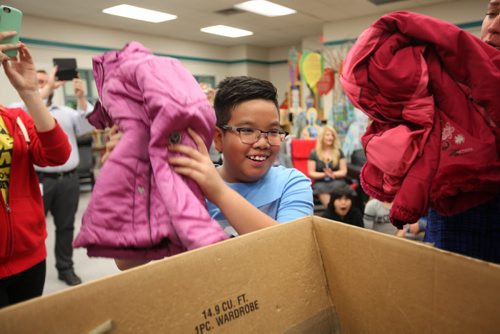 Rovic Climacosa from Sister MacNamara School, places a coat in the "Koats for Kids"  bin  at the start of the 27th annual Koats for Kids Drive Tuesday.   The launch of the annual event kicked off at Sister MacNamara School and has collected and distributed more than 184,000 articles of gently used winter outerwear for thousands of Winnipeg children and families since it started in 1989.   Sept 22, 2015   Ruth Bonneville /Winnipeg Free Press