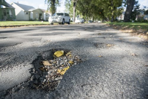 DAVID LIPNOWSKI / WINNIPEG FREE PRESS 150925 September 25, 2015  Potholes on Ashburn Street between Ellice Avenue and Sargent Avenue seen Friday September 25, 2015.