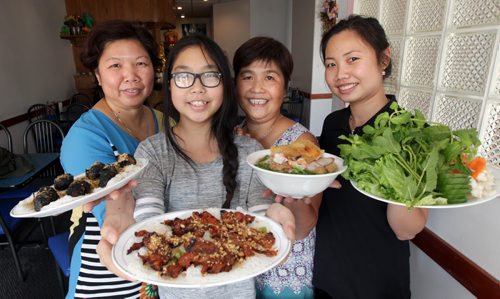 Nhu Quynh Vietnamese Restraunt Review. Left to right, owner Quynh Nguyen holds Grilled Beef in Wrapping Leaves, her daughter Annie Tran holds Charbroiled Pork. Next to her the Chef Oanh Demetrioff shows off the Pnom Penh soup with crepe and shrimp. Nhi Luong far right brandishes the trimmings of mint leaves cukecumbers and more. See Warhaft review. September 25, 2015 - (PHIL HOSSACK / WINNIPEG FREE PRESS)