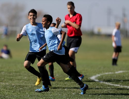 Two players from IRCOM, The Immigrant and Refugee Community Organization of Manitoba Inc. soccer team, celebrate a goal during their game against St. Johns Ravenscourt during the final game of the boys under 13 city recreation final at John Blumberg, Saturday, September 26, 2015. (TREVOR HAGAN/WINNIPEG FREE PRESS)