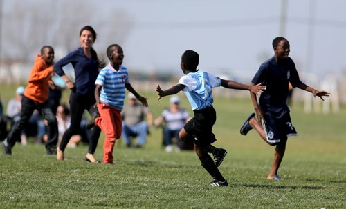 Frank Nayituriki from IRCOM, The Immigrant and Refugee Community Organization of Manitoba Inc. soccer team, celebrates as friends rush the field, after defeating St. Johns Ravenscourt during the final game of the boys under 13 city recreation final at John Blumberg, Saturday, September 26, 2015. (TREVOR HAGAN/WINNIPEG FREE PRESS)
