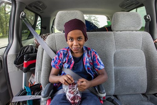 Karin Gordon travels to Emerson, MB to pick up refugees who have made it across the border with the United States. Somali refugee Amin, 6, eats a bag of grapes after getting buckled in Sunday just before leaving Emerson, MB, for Winnipeg. 150927 - Sunday, September 27, 2015 -  MIKE DEAL / WINNIPEG FREE PRESS