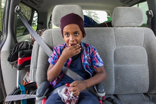 Karin Gordon travels to Emerson, MB to pick up refugees who have made it across the border with the United States. Somali refugee Amin, 6, eats a bag of grapes after getting buckled in Sunday just before leaving Emerson, MB, for Winnipeg. 150927 - Sunday, September 27, 2015 -  MIKE DEAL / WINNIPEG FREE PRESS
