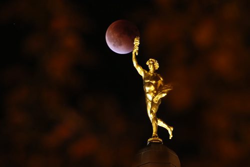 Lunar eclipse on a Supermoon appears behind the Golden Boy at the Manitoba Legislature  in Winnipeg Sunday, September 27, 2015. THE CANADIAN PRESS/John Woods
