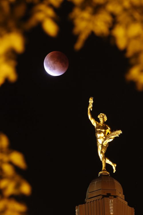 Lunar eclipse on a Supermoon appears behind the Golden Boy at the Manitoba Legislature  in Winnipeg Sunday, September 27, 2015. THE CANADIAN PRESS/John Woods