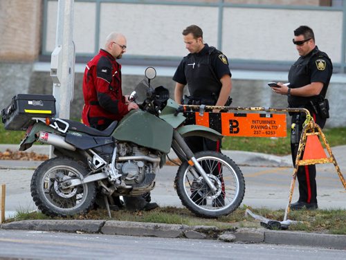 MVC. Motorcycle involved eastbound Portage Ave. at Whytewold Road. Police talk to bike driver. Damage on front of bike. Kawasaki KLR 650. BORIS MINKEVICH / WINNIPEG FREE PRESS  Sept. 28, 2015
