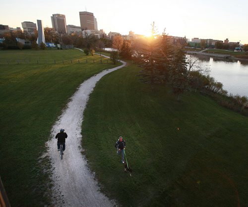 Cyclists and joggers use the trail along the Red River's east shore near Whittier Park across from Waterfront Drive and downtown. September 29, 2015 - (PHIL HOSSACK / WINNIPEG FREE PRESS)