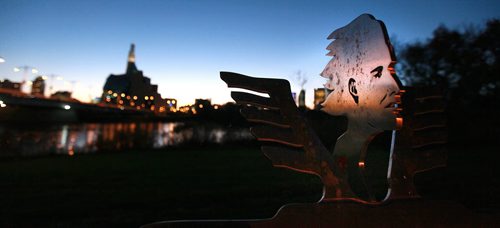 A steel sculpture in tribute to Gabrielle Roy watches over St Boniface beside the Provencher Bridge at dusk. September 29, 2015 - (PHIL HOSSACK / WINNIPEG FREE PRESS)