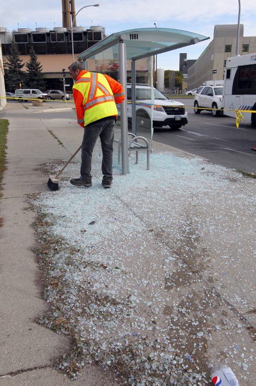 Workers clean up the mess left behind when a car smashed the glass bush shelter on Maryland near Notre Dame. Injuries reported. BORIS MINKEVICH / WINNIPEG FREE PRESS  Sept. 29, 2015