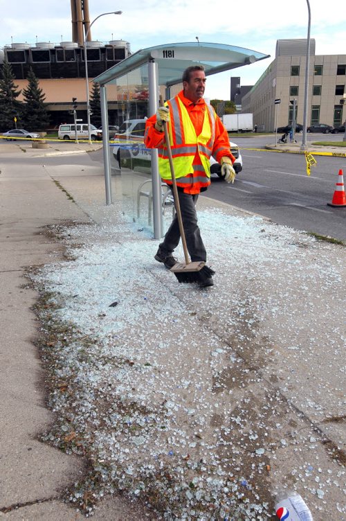 Workers clean up the mess left behind when a car smashed the glass bush shelter on Maryland near Notre Dame. Injuries reported. BORIS MINKEVICH / WINNIPEG FREE PRESS  Sept. 29, 2015