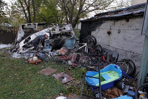 Fire on Grove. Fire inspector checks out a camper that burnt and spread to the rear of the home. BORIS MINKEVICH / WINNIPEG FREE PRESS  Sept. 30, 2015